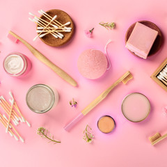 Obraz na płótnie Canvas Plastic-free, zero waste cosmetics, flat lay pattern on a pink background, square overhead shot. Bamboo toothbrushes and cotton swabs, konjac sponge, natural organic products
