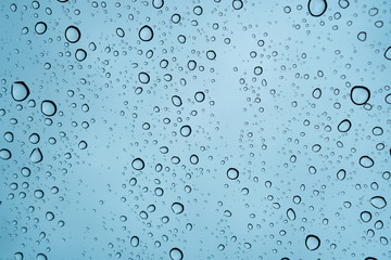Raindrops falling on the glass of the car. Suitable for use in abstract backgrounds.