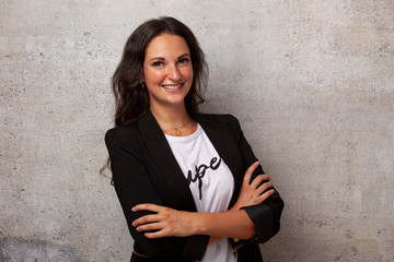 Junge Business mit Blazor lachend Frau vor Beton Wand