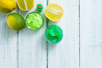 beauty care cosmetic cream samples with citrus fruits on white wood