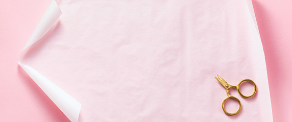 banner of paper and gold scissors on a pink background. empty blank frame for background. shot from above. copy space