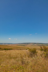 Fototapeta premium Road through the southern grasses on the hill