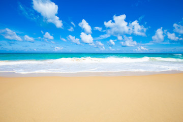 Obraz premium Sea wave on summer white beach with cloud sky