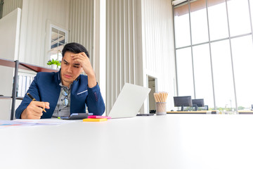 A young Asian businessman looks at the company's bad financial results. Makes you feel disappointed