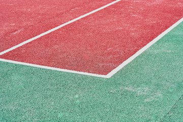 Corner markings on red tennis court for game.