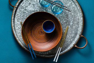 set the table with empty plates and glasses, spices and herbs. on the blue. shot from above. copy space