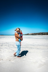 Mother carrying son at beach