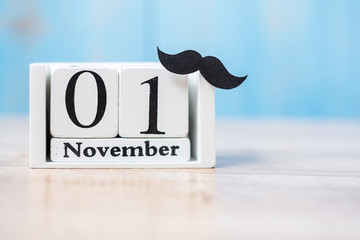 1 November Calendar and mustache on wood table background. Father, International men day, Prostate Cancer Awareness and World cancer day concept