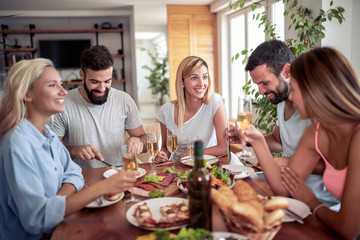 Group of happy friends eating home