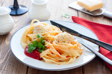 Tagliatelle pasta with meat balls and sauce on a plate, horizontal