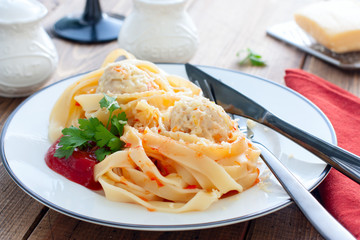 Tagliatelle pasta with meat balls and sauce on a plate, horizontal