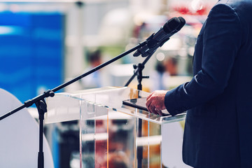 Male Speaker Standing In Front Of Microphones