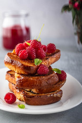 French toasts, French toasts made of sliced brioche with fresh raspberries, honey and mint. Delicious breakfast or dessert