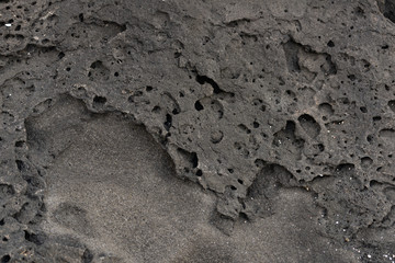 Amazing frozen lava pattern. Dark grey black slate background or texture.