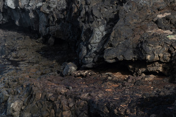 Close-up ledge in a rocky steep bank formed from frozen black lava on the Canary Island of Lanzarote