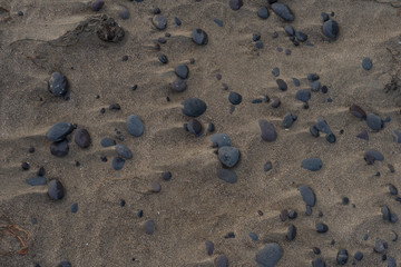 Smooth surf-rolled stones tamped like paving stones on wet sand