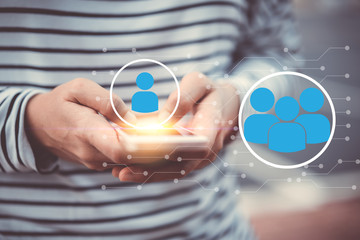 Woman hand hold using smart phone at outdoor park street with people icon and line dot background. Copy space of technology business and travel holiday concept.