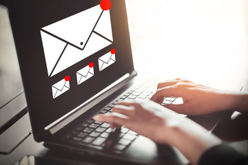 Woman hand using laptop with email icon background at cafe shop. Technology business and internet communication concept.