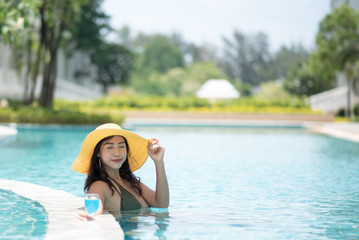 Young Woman Wearing Hat Holding Drink In Swimming Pool