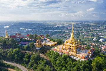 Naklejka premium Golden mountain on the top of mountain backgroud city town in Thailand