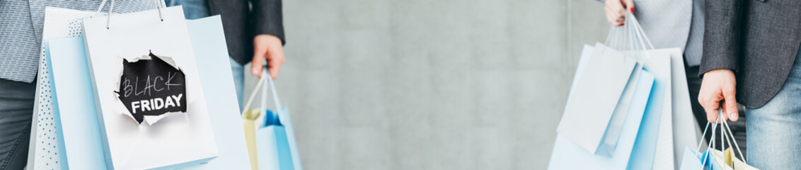 Black friday shopping. Consumerism promotion. People with paper bags.