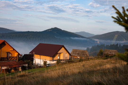 Early foggy morning in the mountains. Carpathians, Bukovel, lawn houses. © BondarMAN