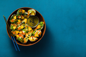 vegan spring rolls of vegetables and peach with pistachio sauce on a tray. healthy food . shot from above. copy space