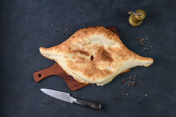 Georgian bread lavash on wooden board on dark rustic background, top view
