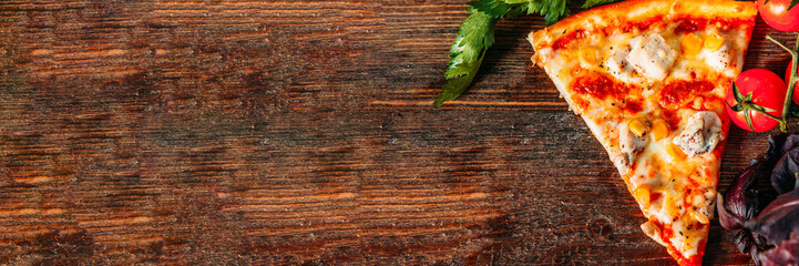 Culinary background. Traditional Italian cuisine. Chicken pizza slice on rustic brown wooden table.