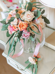 Bridal bouquet with pink and coral roses. Groom's boutonniere with similar flowers. Traditional accessories for wedding.