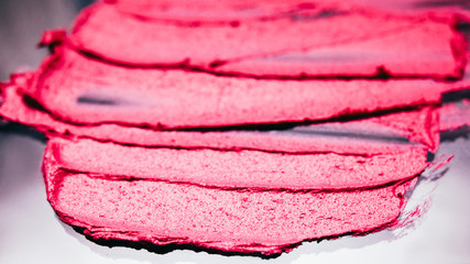 Smeared lipstick. Makeup artistry business. Crimson red strokes on dark background.