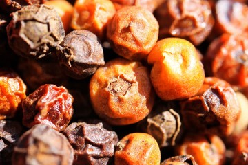 Macro close up of isolated pile with red and black kampot peppercorns from Cambodia
