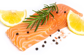 Fresh salmon steak with herbs and lemon isolated on white background