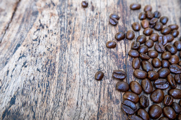Coffee beans are on brown wooden table background
