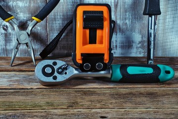 tape measure and pliers on a wooden background