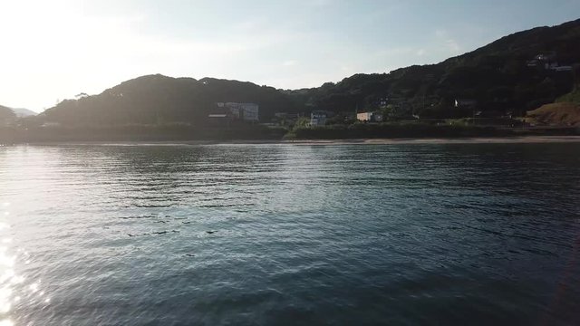 沖合から海岸に向かう 海面に反射する太陽 朝 空撮 トラックアップ 前進 低空 v10_253(DJI_0005)