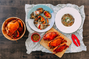 Top view of Fish Sauce-Fermented raw Prawns and Sea Crab with Pickled Crab Eggs and Steamed Giant Mud Crabs served with Thai style spicy seafood sauce.