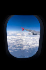 Wing of an airplane flying above beautiful cloud
