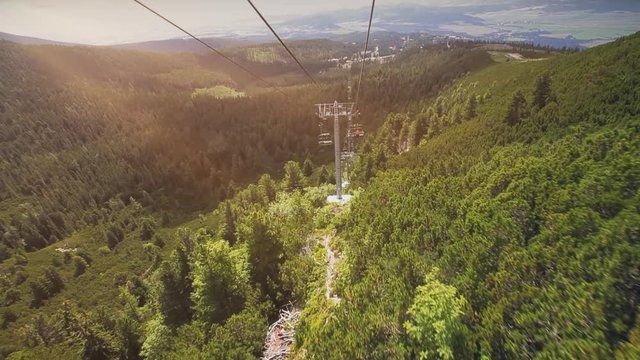 Mountain Chairlift in Summer Season Tatry Highland. Nobody in Cabins of Ziplining Camera Zooming Out. Long Shot of Cableway over Green Pine Forest. Slovakia Recreation. Footage Shot Full HD