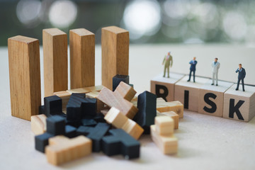Miniature people businessmen stand on cube word with risk. Risk analysis for investment
