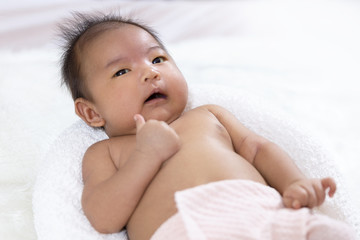 Cute asian newborn baby lying on white fur towel,portrait of little child boy,five week old.