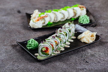 Various kinds of sushi served on black stone