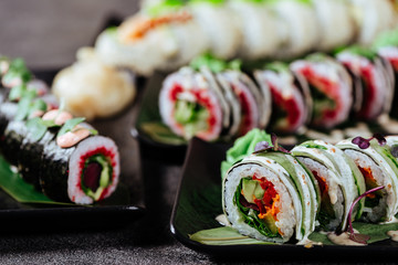 Various kinds of sushi served on black stone