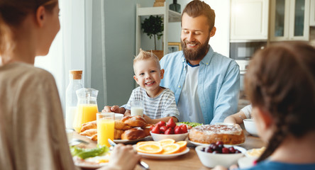family mother father and children have Breakfast in kitchen in morning.