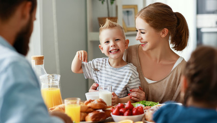 family mother father and children have Breakfast in kitchen in morning.