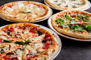 Traditional Italian pizza on a dark background top view copy space.