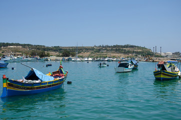 Naklejka na ściany i meble Marsaxlokk, Malta. Luzzu traditional eyed colorful boats in the harbor of fishing village, Mediterranean Sea.
