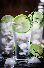 Classic gin tonic cocktail with lime, ice and rosemary. Vintage bar, bar tools. With copy space