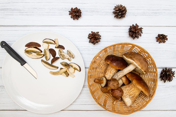 Grzyby w koszyczku na jasnym drewnianym tle