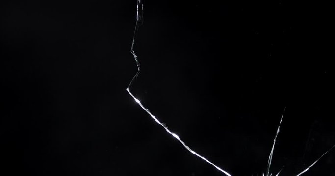 Shattered and broken glass shards flying through the air after crush broken window on a black background
